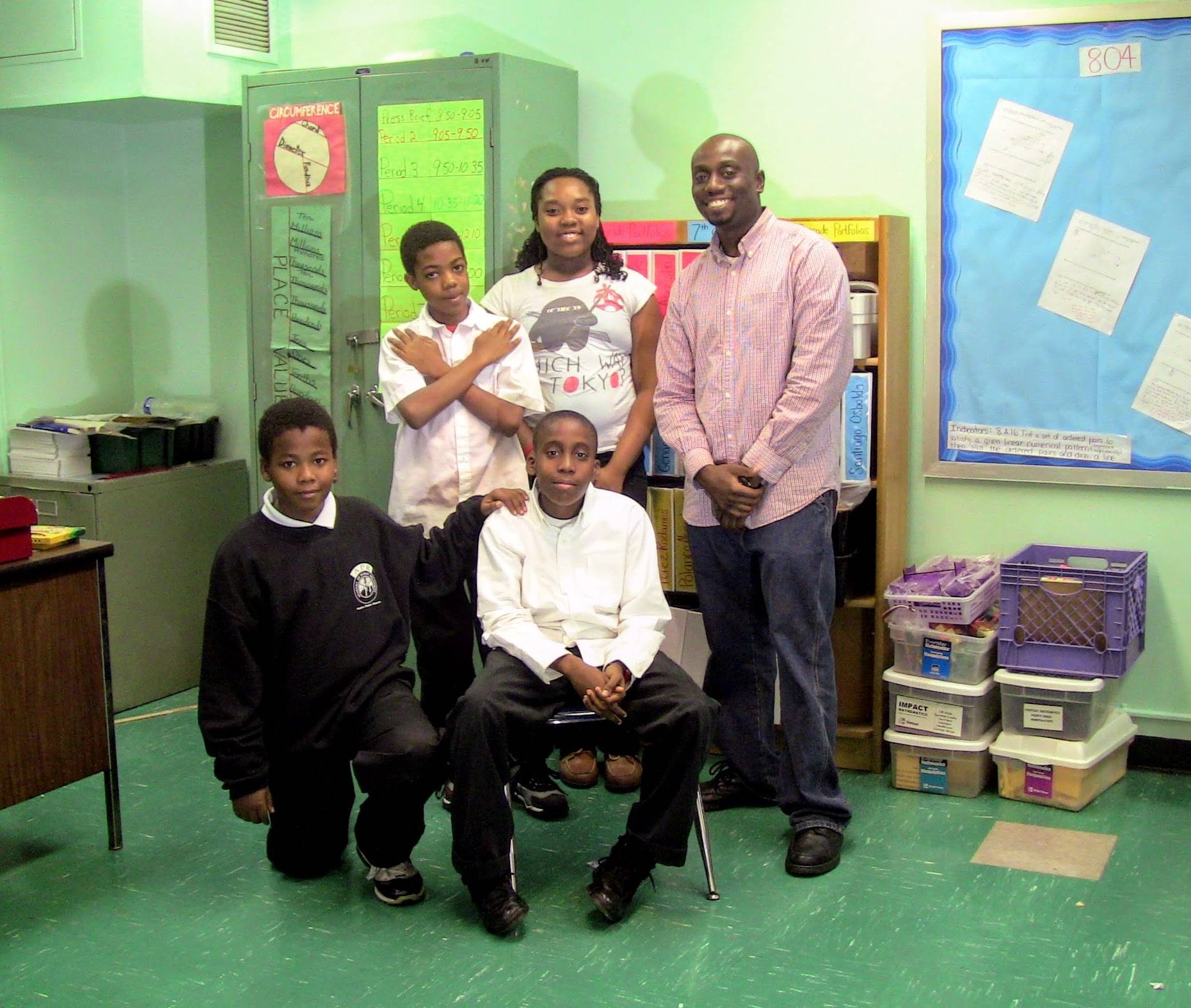 Four after school program students take a photo during journalism class with their instructor.