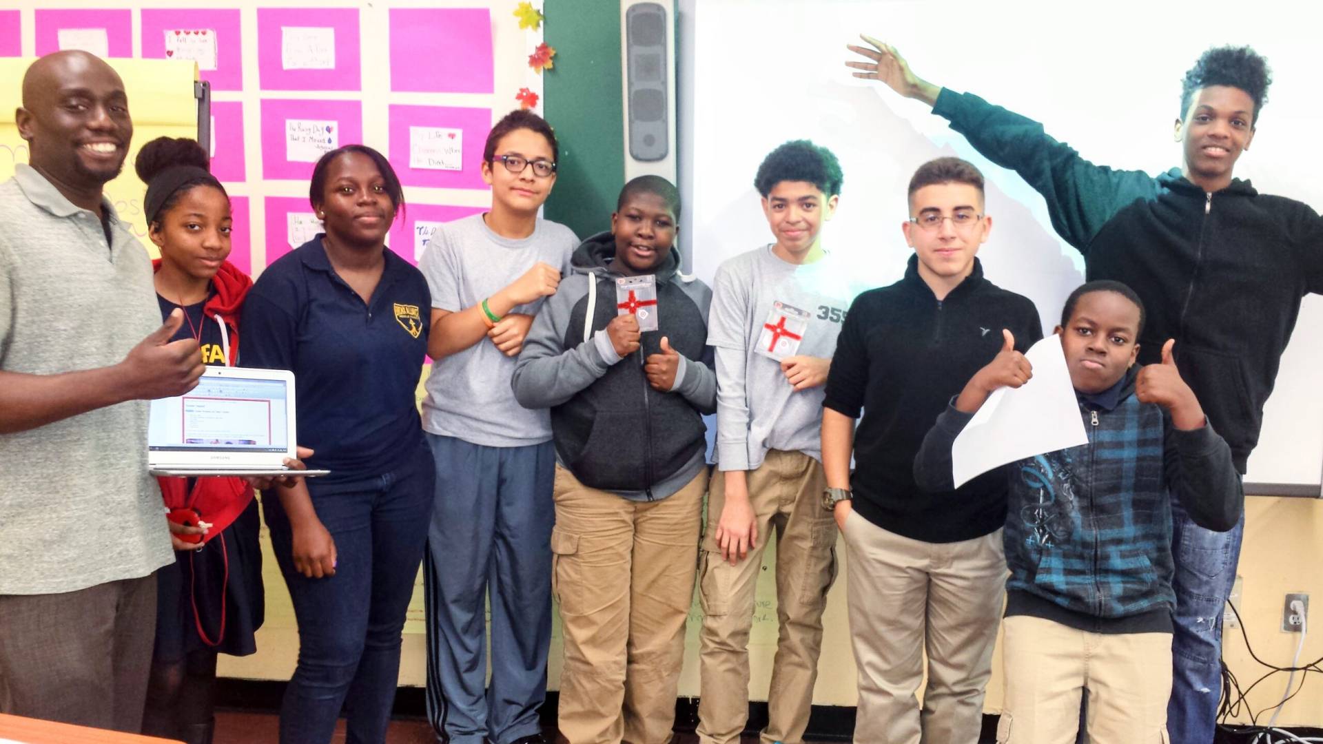 A group of students take a photo with heir instructor after coding class. including two that received a prize for best website design.